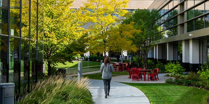 Employee walking in courtyard on campus